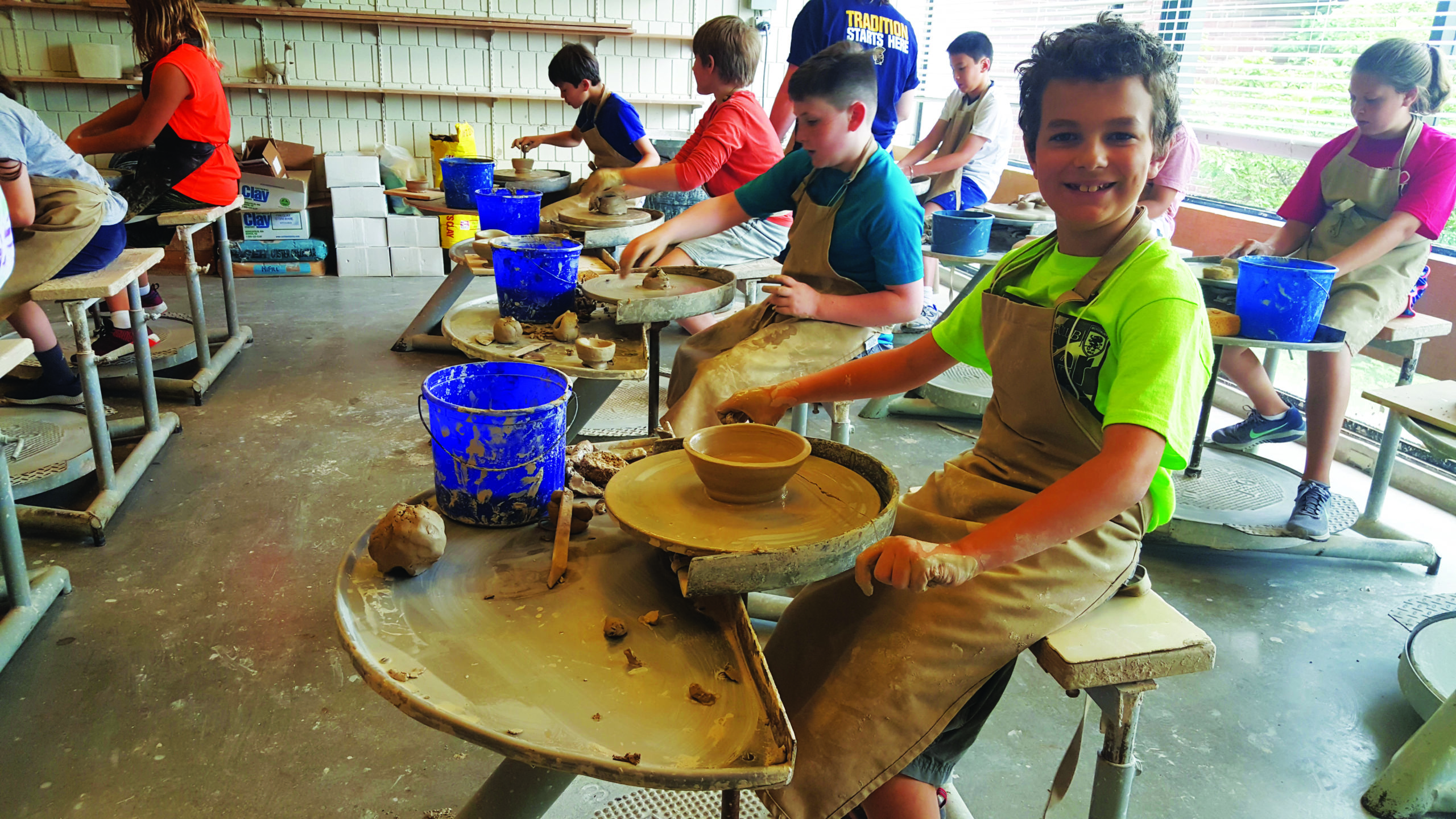 explor pottery ExplorSchool students in a pottery class sitting on pottery wheels