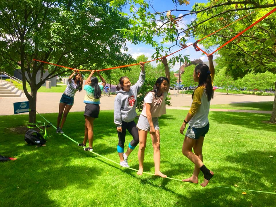EYM slack lining EYM students slack lining outside