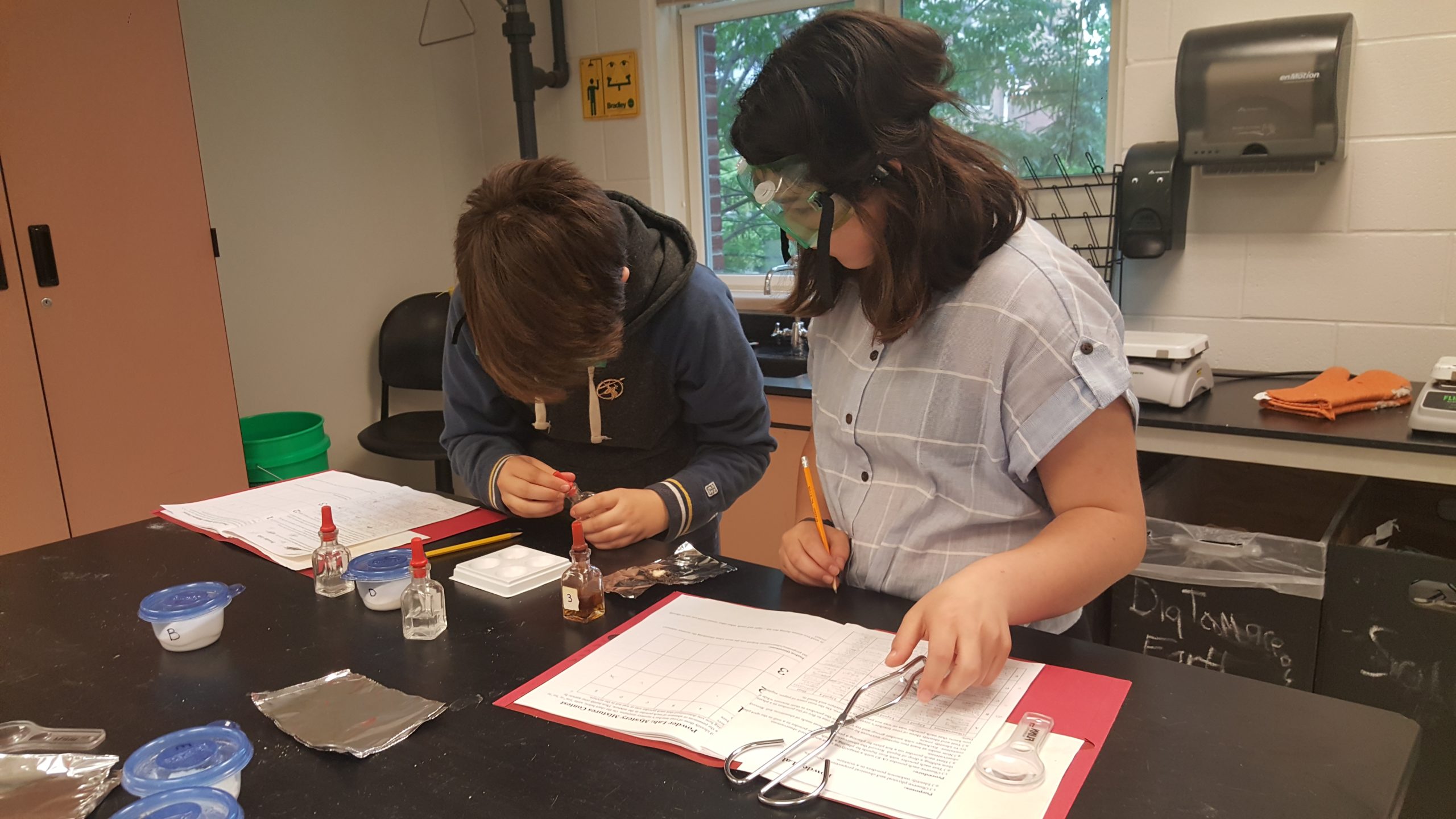explor science ExplorSchool students wearing goggles and doing a science experiment