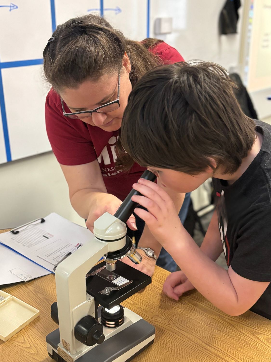 Kathy helping student with microscope